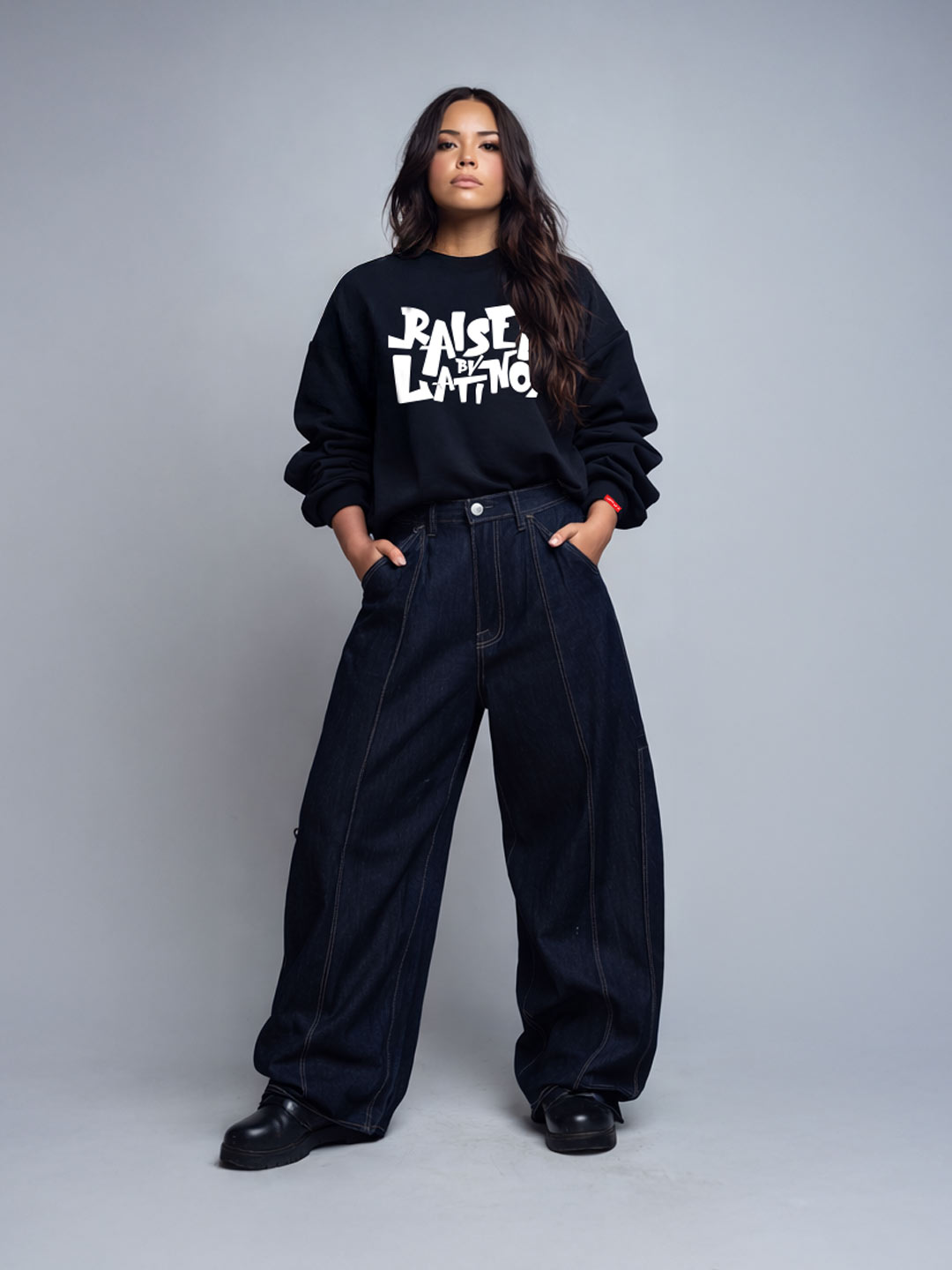 Female model wearing the Champions Crew black sweatshirt with white graffiti logo and wide dark denim, front view