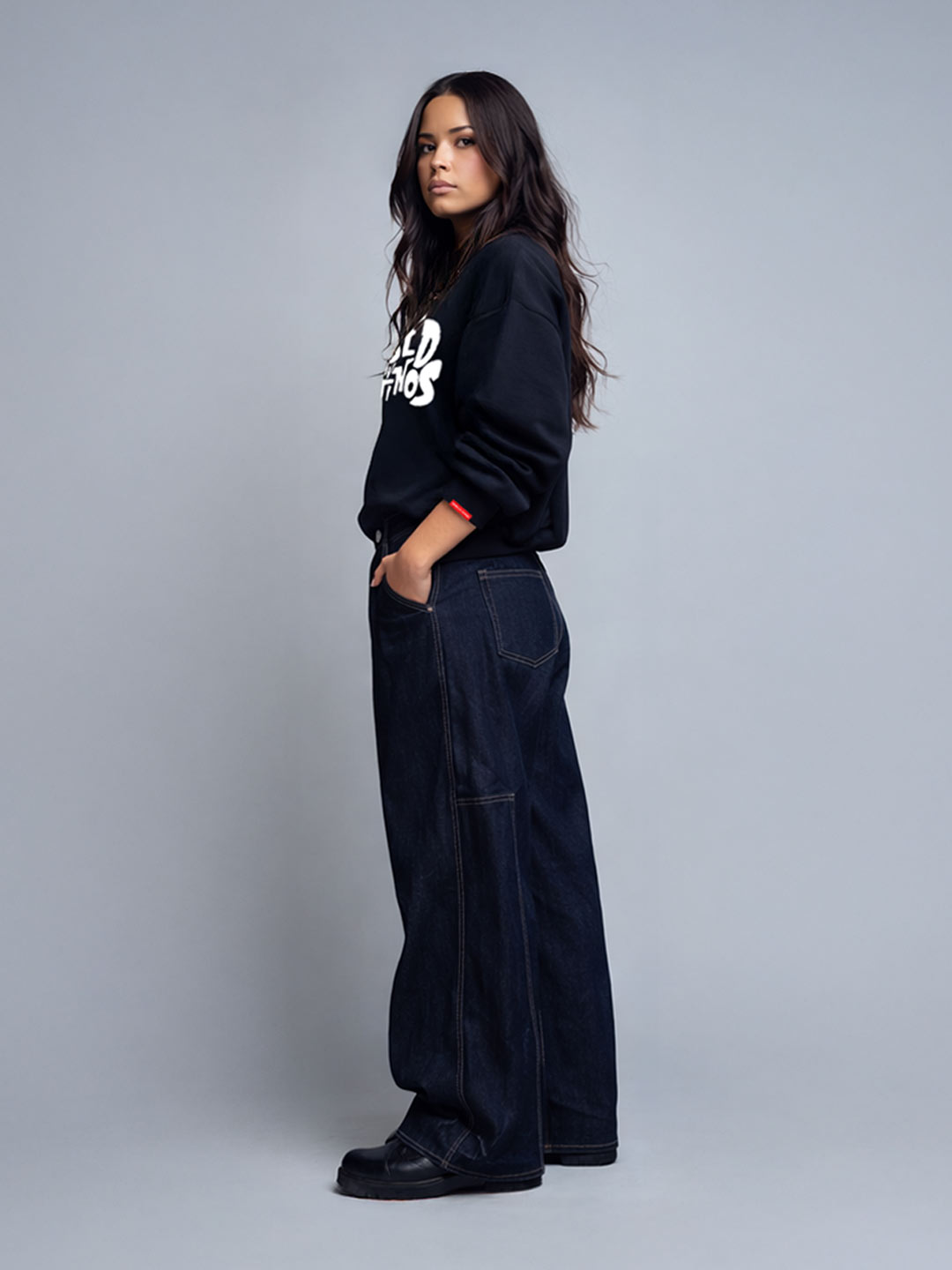 Female model wearing the Champions Crew black sweatshirt with white graffiti logo, side view