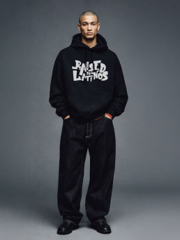 Male model wearing the Champions Hoodie in black with white graffiti chest print, front view