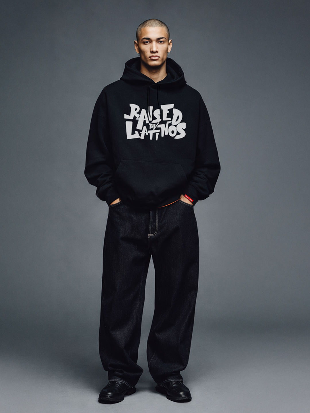 Male model wearing the Champions Hoodie in black with white graffiti chest print, front view