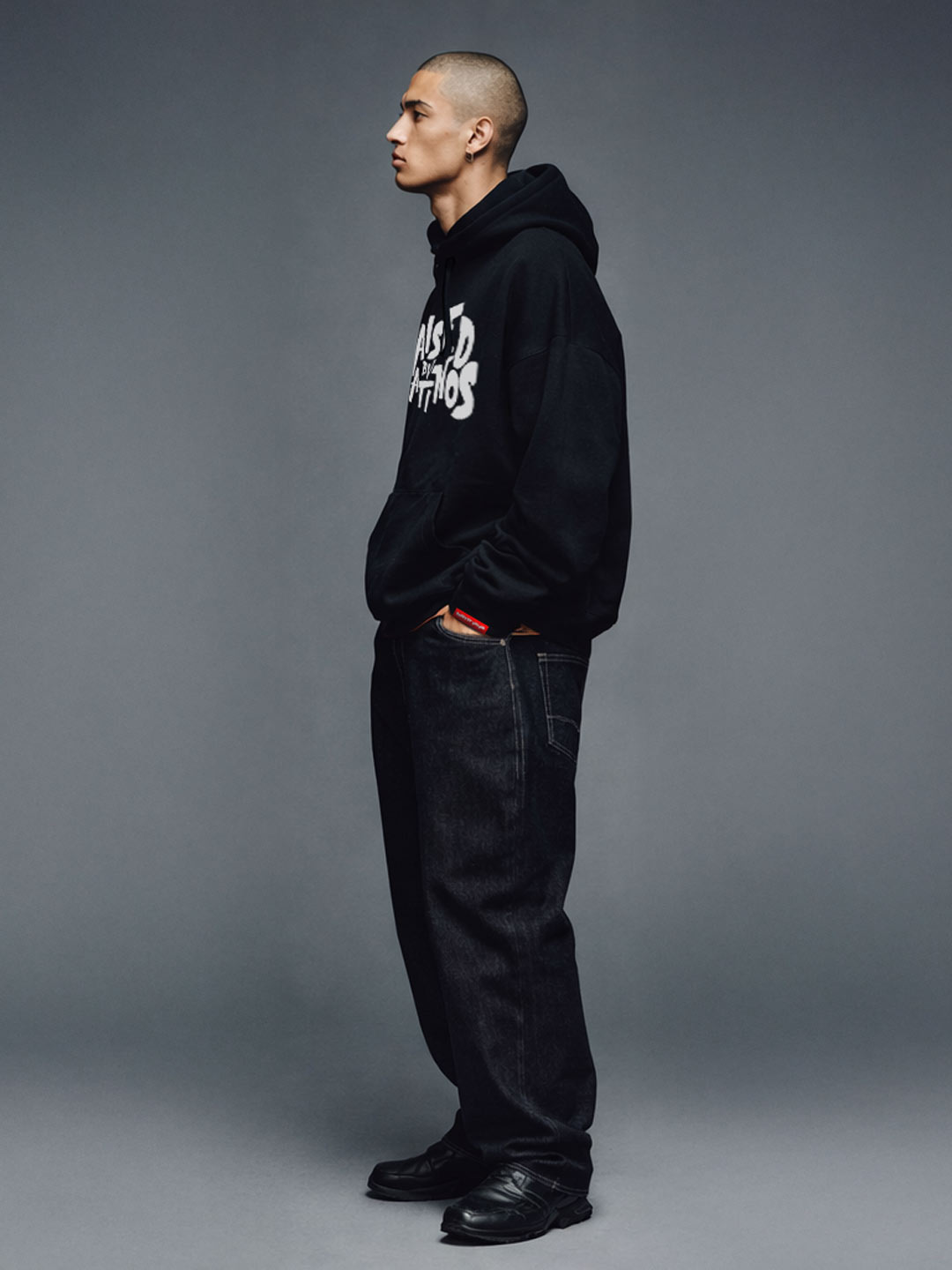 Male model wearing the Champions Hoodie in black, three-quarter view