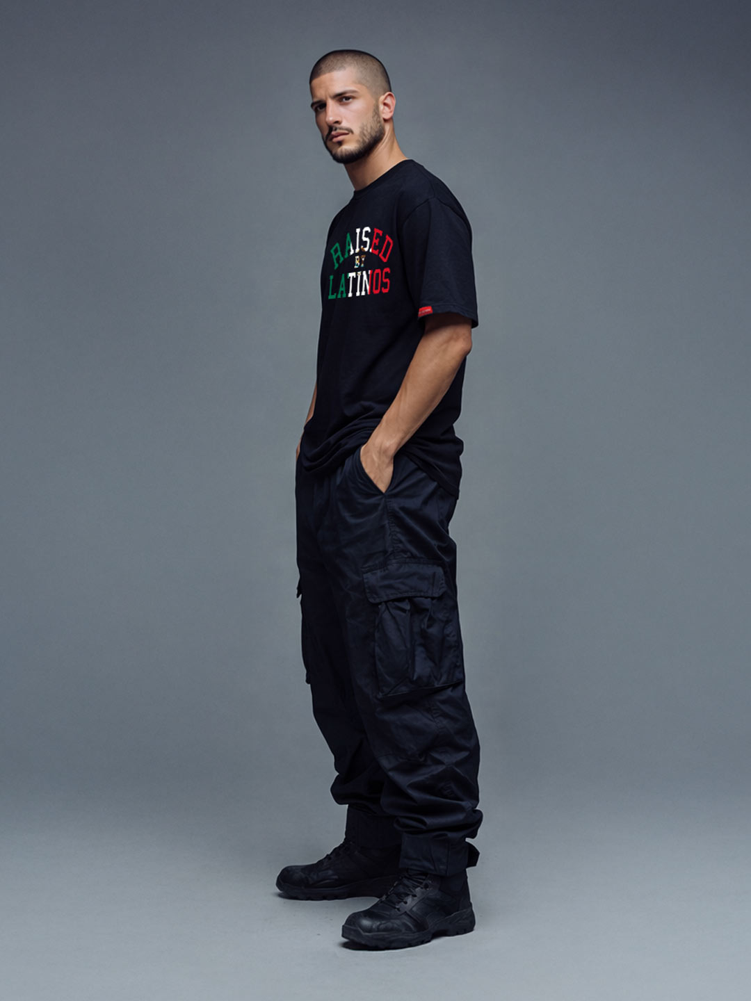 Male model wearing the Firmes y Unidos black t-shirt with tricolour chest print, three-quarter view